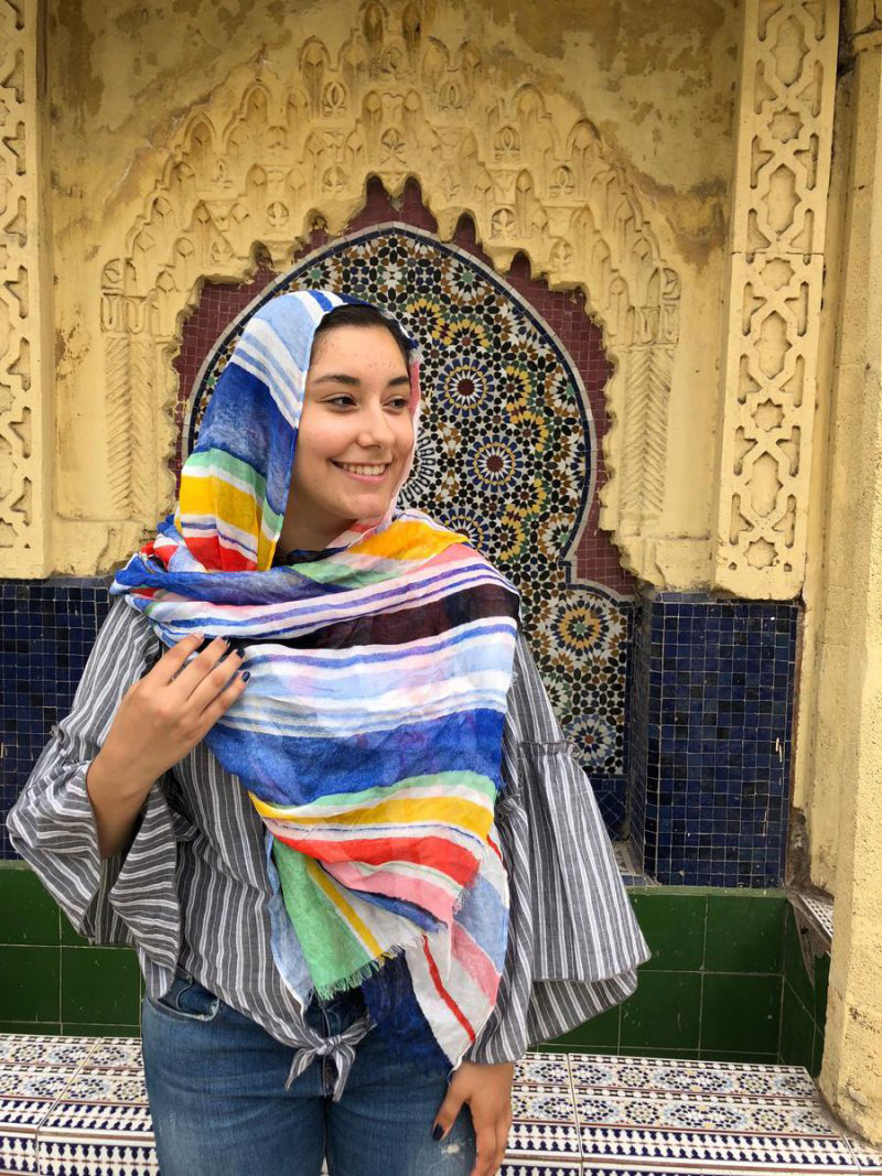 Student in Morocco with tile wall behind her