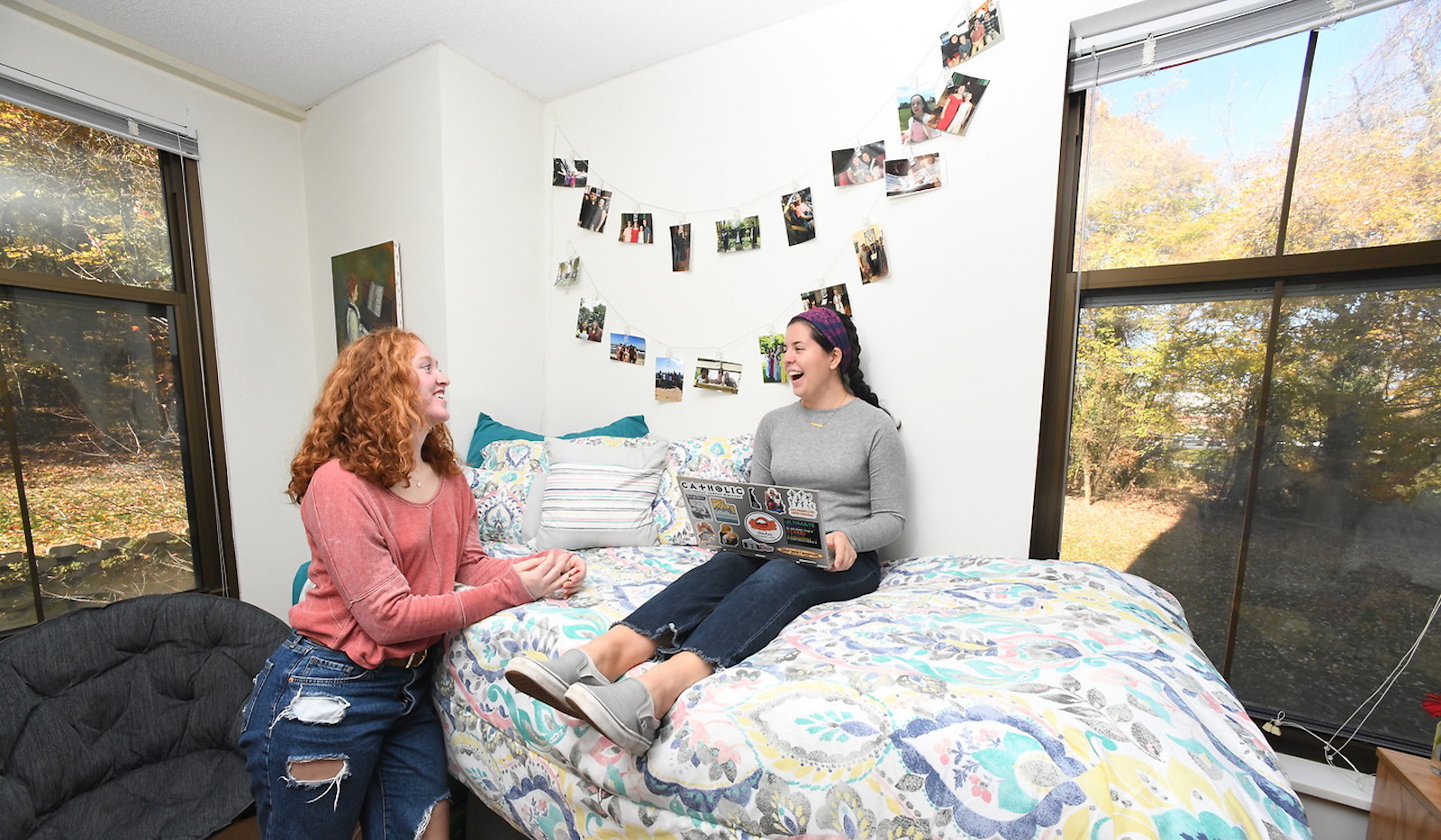 Two girls laughing and talking in a nicely decorated Opus Hall room