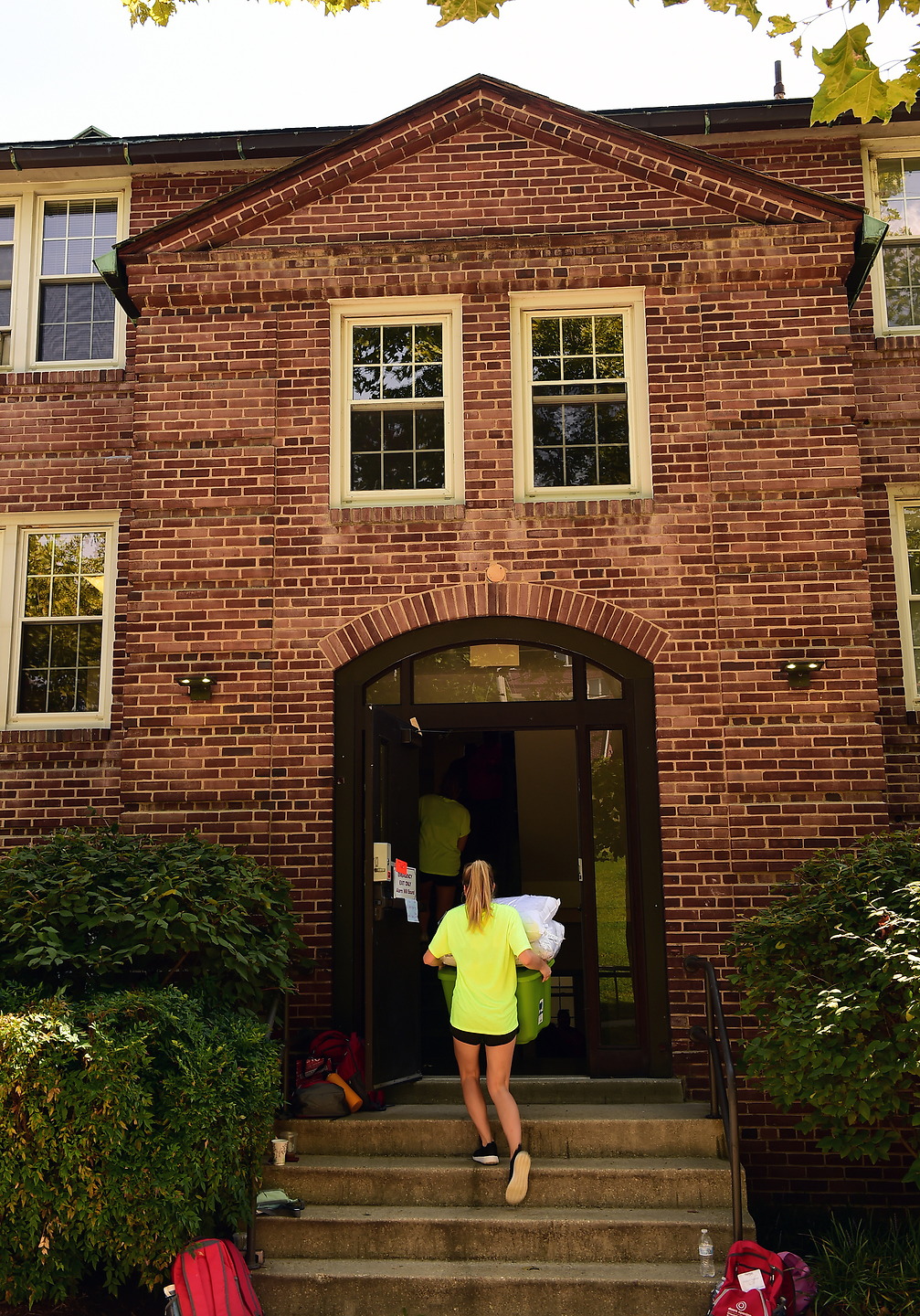 Student carries a box into the entrance of Ryan Hall as she moves in