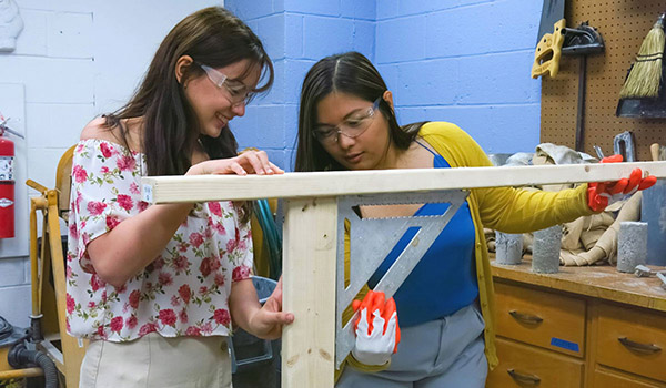 Two female students working on a construction project