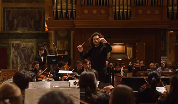 CatholicU student conducting orchestra during performance at St. MAtthew's Cathedral in Washington, DC