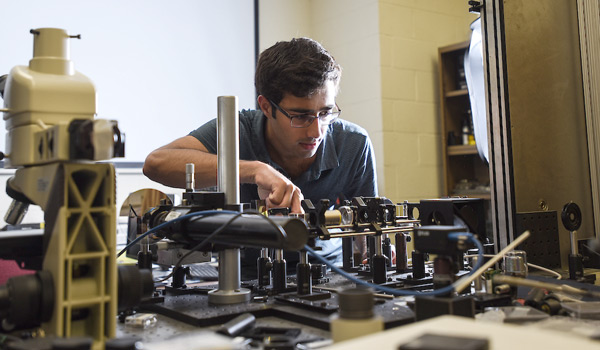 An electric engineering student working on a machine.