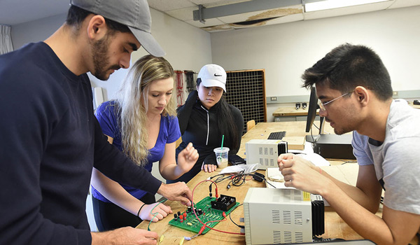 A group of students working on a device in their physics class.